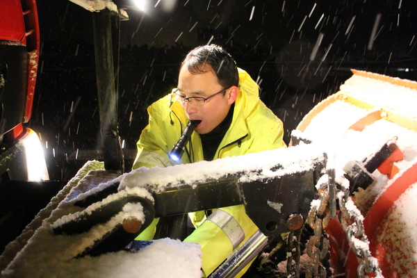 風雪中，馬巢公司夜班除雪隊員李夫勝正在調(diào)試除雪鏟大燈.jpg